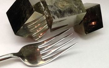 pyrite crystals bound together next to a fork